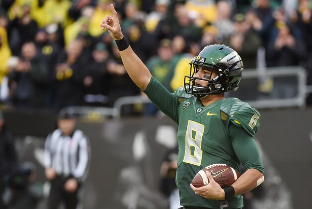 Oregon quarterback Marcus Mariota (8) celebrates after scoring a touchdown during the first quarter of an NCAA college football game against the Colorado on Saturday, Nov. 22, 2014, in Eugene, Ore. (AP Photo/Steve Dykes)