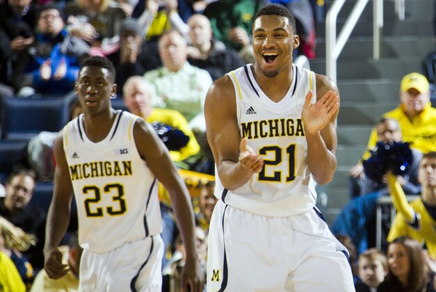 Michigan guard Zak Irvin (21) reacts after a basket at the end of the first half of an NCAA college basketball game against Detroit in Ann Arbor, Mich., Thursday, Nov. 20, 2014. Michigan won 71-62. (AP Photo/Tony Ding)