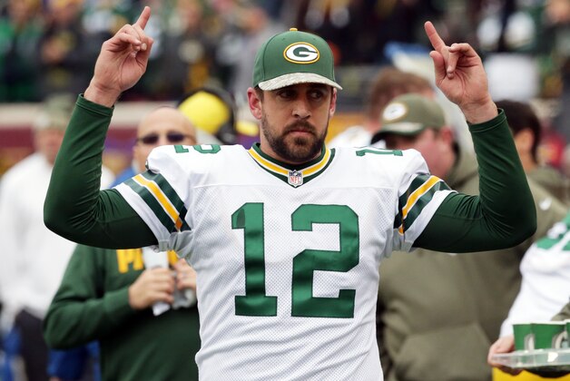 Green Bay Packers quarterback Aaron Rodgers signals touchdown as officials review one during the second half of an NFL football game against the Minnesota Vikings, Sunday, Nov. 23, 2014, in Minneapolis. (AP Photo/Jim Mone)