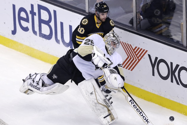 Pittsburgh Penguins goalie Marc-Andre Fleury (29) clears the puck away from Boston Bruins left wing Daniel Paille (20) during the first period of an NHL hockey game in Boston, Monday, Nov. 24, 2014. (AP Photo/Charles Krupa)