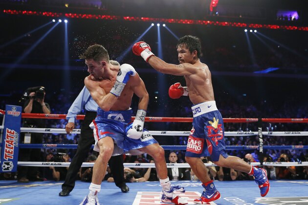 WBO welterweight champion Manny Pacquiao, right, of the Philippines fights with WBO junior welterweight champion Chris Algieri of the United States during their world welterweight title boxing match at the Venetian Macao in Macau, Sunday, Nov. 23, 2014. (AP Photo/Kin Cheung)