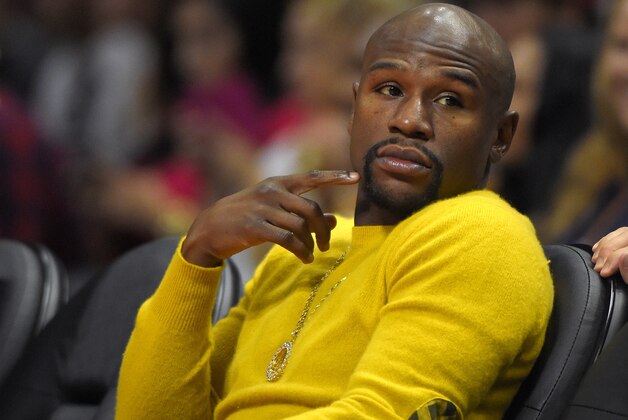 Boxer Floyd Mayweather Jr. watches the Los Angeles Clippers play the Phoenix Suns during the first half of a preseason NBA basketball game, Wednesday, Oct. 22, 2014, in Los Angeles. (AP Photo/Mark J. Terrill)