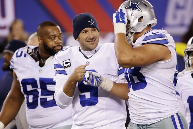 Dallas Cowboys quarterback Tony Romo (9) walks off the field with teammates at half time of an NFL football game against the New York Giants, Sunday, Nov. 23, 2014, in East Rutherford, N.J. (AP Photo/Julio Cortez)