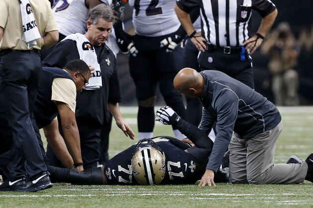 New Orleans Saints nose tackle Brodrick Bunkley (77) is tended to after being injured in the first half of an NFL football game against the Baltimore Ravens in New Orleans, Monday, Nov. 24, 2014. (AP Photo/Jonathan Bachman)