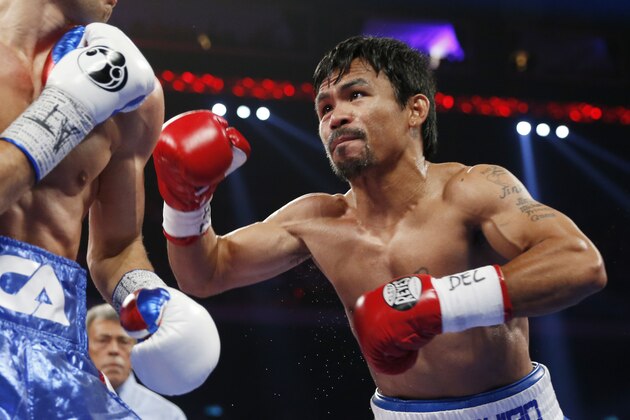 WBO welterweight champion Manny Pacquiao, right, of the Philippines and WBO junior welterweight champion Chris Algieri of the U.S., exchange punches during their world welterweight title boxing match at the Venetian Macao in Macau, Sunday, Nov. 23, 2014. (AP Photo/Kin Cheung)