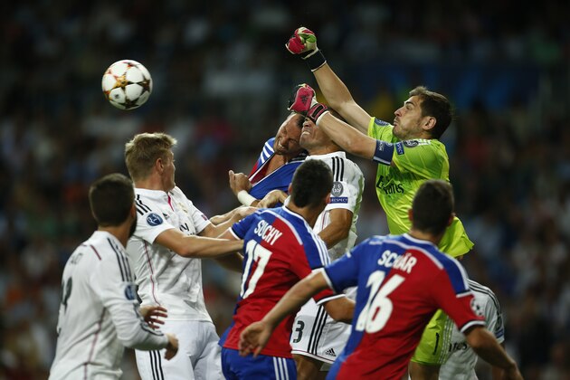 Real's Iker Casillas tries to push the ball away during the Champions League Group B soccer match between Real Madrid and Basel at the Santiago Bernabeu stadium in Madrid, Spain, Tuesday, Sept. 16, 2014. (AP Photo/Andres Kudacki)