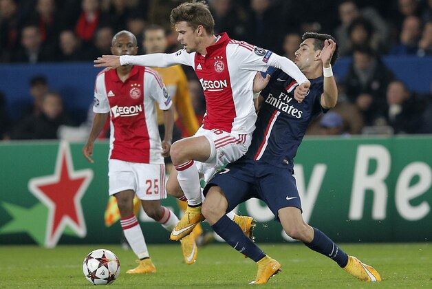 Ajax's Lucas Andersen, left, is tackled by PSG's Javier Pastore during the Champions League Group F soccer match between Paris Saint Germain and Ajax at the Parc des Princes stadium in Paris, France, Tuesday, Nov. 25, 2014. (AP Photo/Christophe Ena)