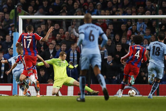 Manchester City's Sergio Aguero, left, scores the third goal of his team during the Champions League group E soccer match between Manchester City and Bayern Munich, at the Etihad Stadium, in Manchester, England, Tuesday, Nov. 25, 2014. Manchester City won 3-2. (AP Photo/Jon Super)