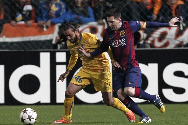 APOEL's Efstathios Aloneftis fights for the ball with Barcelona's Lionel Messi during a Champions League Group F soccer match between APOEL and FC Barcelona at GSP stadium, in Nicosia, Cyprus, Tuesday, Nov. 25, 2014. (AP Photo/Petros Karadjias)