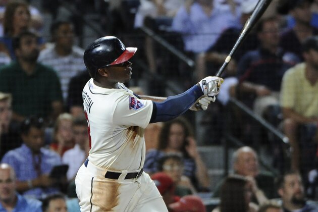 Atlanta Braves' Justin Upton hits a two-run homer that also scores Phil Gosselin during the fourth inning of a baseball game against the Oakland Athletics Sunday, Aug. 17, 2014, in Atlanta. (AP Photo/David Tulis)