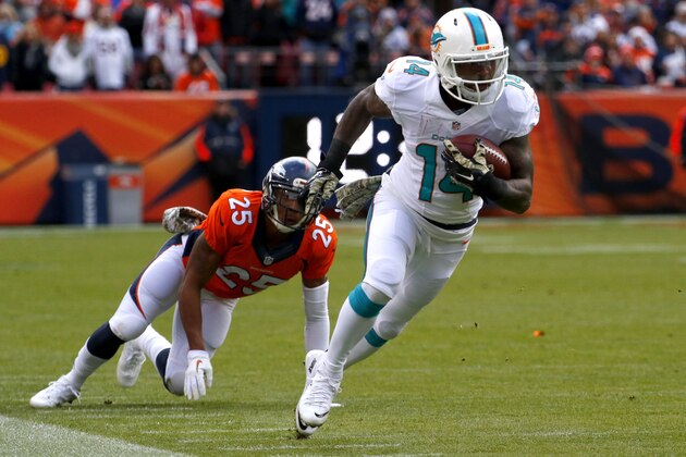 Miami Dolphins wide receiver Jarvis Landry (14) breaks free from Denver Broncos cornerback Chris Harris (25) during the first half of an NFL football game, Sunday, Nov. 23, 2014, in Denver. (AP Photo/Jack Dempsey)