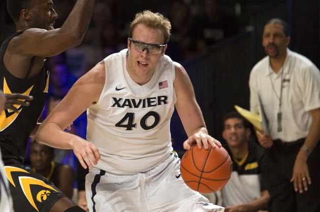 Xavier's Matt Stainbrook, right, dribbles tightly guarded by Iowa's Gabriel Olaseni during the first half of an NCAA college basketball game in Paradise Island, Bahamas, Thursday, Nov. 28, 2013. Iowa won 77-74 in overtime. (AP Photo/Bahamas Visual Services, Dante Carrer)