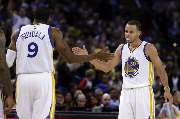 Golden State Warriors' Andre Iguodala, left, and Stephen Curry celebrate during a timeout in the second half of an NBA basketball game against the Utah Jazz on Friday, Nov. 21, 2014, in Oakland, Calif. (AP Photo/Ben Margot)