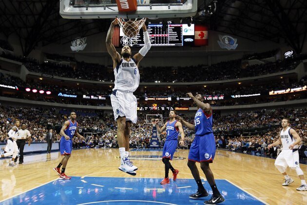 Dallas Mavericks' Tyson Chandler dunks as Philadelphia 76ers' Hollis Thompson (31), Michael Carter-Williams (1) and Henry Sims (35) watch in the first half of an NBA basketball game, Thursday, Nov. 13, 2014, in Dallas. (AP Photo/Tony Gutierrez)