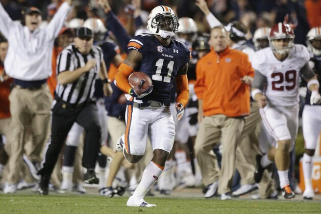 FILE - In this Nov. 30, 2013 file photo, Auburn cornerback Chris Davis (11) returns a field goal attempt 109-yards to score the winning touchdown over Alabama during the second half of an NCAA college football game in Auburn, Ala.Pursuing is punter Cody Mandell (29). Davis's 109-yard return of a missed field goal to beat Alabama was one of the Iron Bowl's and the season's most memorable plays. (AP Photo/Dave Martin, file)