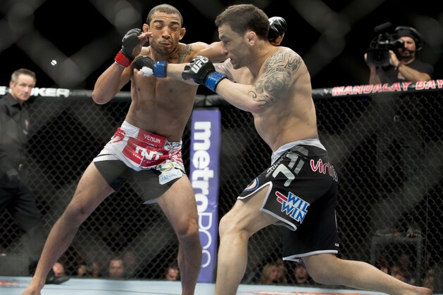 Jose Aldo, of Rio de Janeiro, left, trades punches with Frankie Edgar during their UFC 156 featherweight mixed martial arts title match, Saturday, Feb. 2, 2013 at The Mandalay Bay Resort & Casino in Las Vegas. Aldo won by unanimous decision. (AP Photo/Eric Jamison)