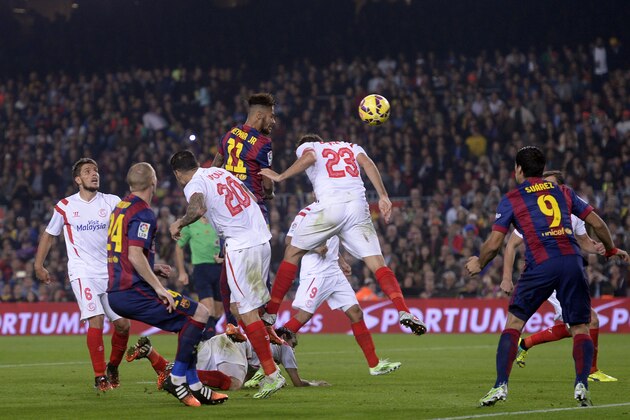 FC Barcelona's Neymar, from Brazil, top. heads for the ball towards goal,  during a Spanish La Liga soccer match between FC Barcelona and Sevilla, at the Camp Nou stadium in Barcelona, Spain, Saturday, Nov. 22, 2014. FC Barcelona Lionel Messi, from Argentina, set a La Liga scoring record of 253 goals when he claimed a hat-trick in Saturday's match at the Camp Nou stadium against Sevilla.  (AP Photo/Manu Fernandez)