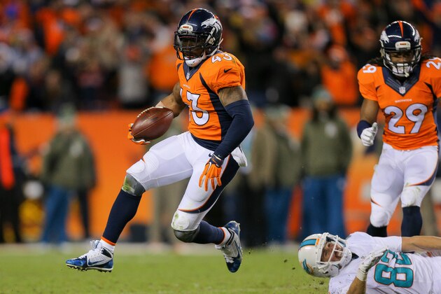 DENVER, CO - NOVEMBER 23:  Strong safety T.J. Ward #43 of the Denver Broncos avoids a tackle attempt by wide receiver Brian Hartline #82 of the Miami Dolphins after an interception at Sports Authority Field at Mile High on November 23, 2014 in Denver, Colorado.  (Photo by Justin Edmonds/Getty Images)