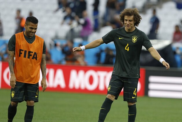Brazil's David Luiz, right, and his teammate Dani Alves joke each other during an official training session the day before the group A World Cup soccer match between Brazil and Croatia at the Itaquerao Stadium in Sao Paulo, Brazil, Wednesday, June 11, 2014. (AP Photo/Kirsty Wigglesworth)