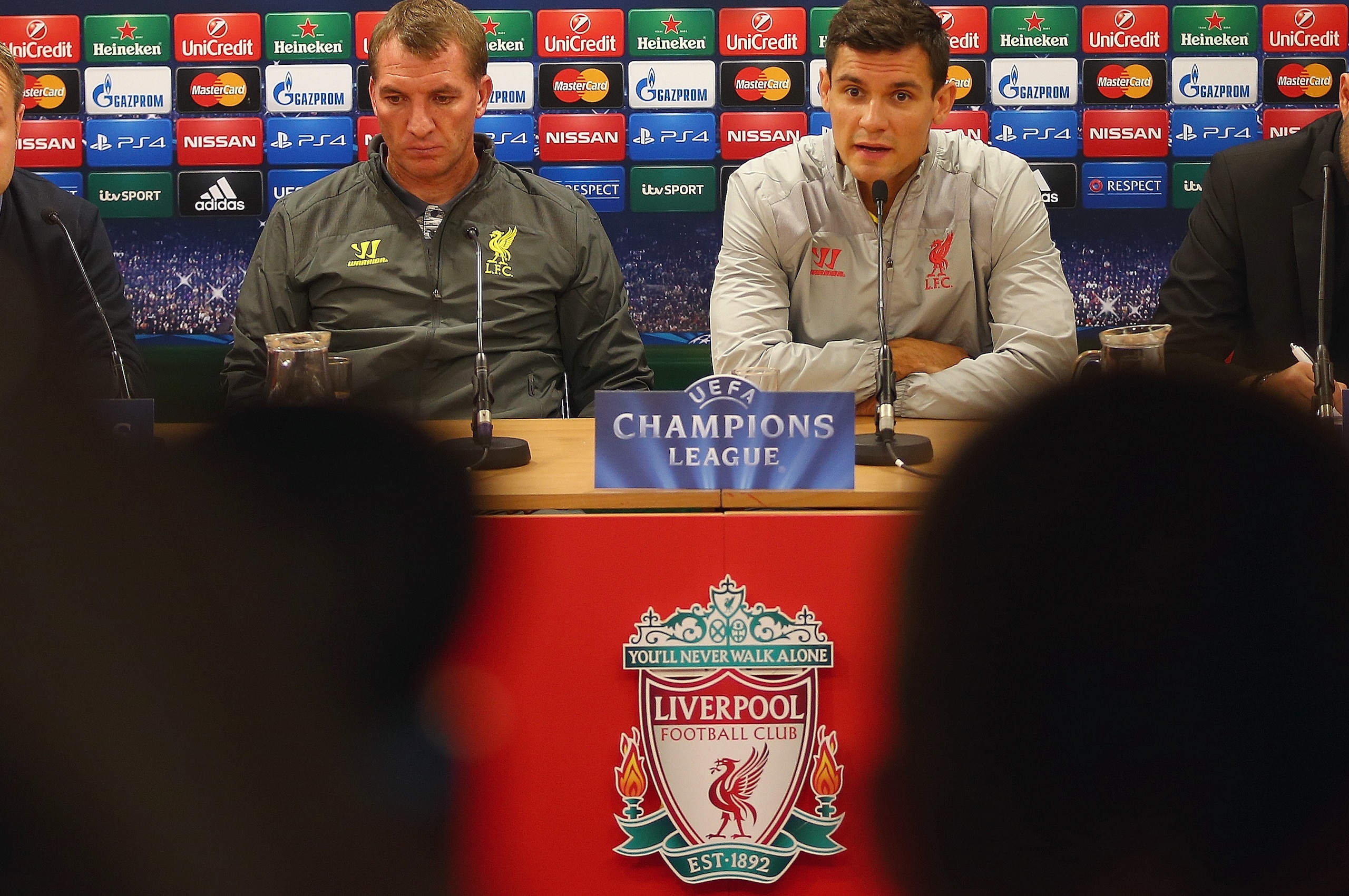 LIVERPOOL, ENGLAND - SEPTEMBER 15:  Liverpool manager Brendan Rodgers deep in thought whilst sitting next to his defender Dejan Lovren during a press conference ahead of their UEFA Champions League group B match against PFC Ludogorets on September 15, 2014 in Liverpool, United Kingdom.  (Photo by Clive Brunskill/Getty Images)
