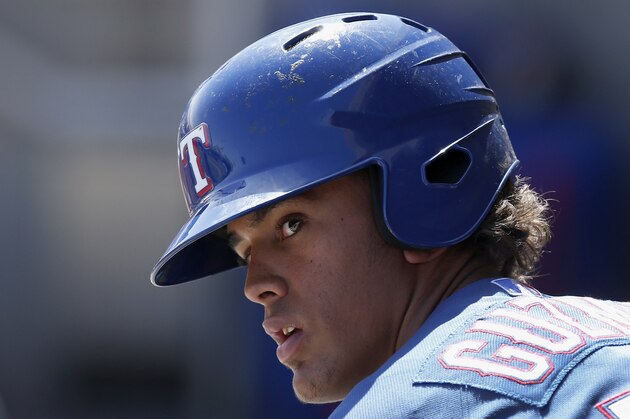 Texas Rangers' Ronald Guzman waits in the dugout prior to a spring training baseball game against the Milwaukee Brewers, Tuesday, March 18, 2014, in Phoenix.  The Brewers defeated the Rangers 9-3. (AP Photo/Ross D. Franklin)
