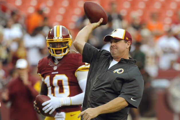 Washington Redskins quarterback Robert Griffin III (10) watches as head coach Jay Gruden throws a pass during warm ups before an NFL preseason football game against the Cleveland Browns Monday, Aug. 18, 2014, in Landover, Md. (AP Photo/Richard Lipski)