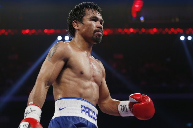WBO welterweight champion Manny Pacquiao of the Philippines walks to his corner after a round against WBO junior welterweight champion Chris Algieri of the U.S. during his world welterweight title boxing match at the Venetian Macao in Macau, Sunday, Nov. 23, 2014. (AP Photo/Kin Cheung)