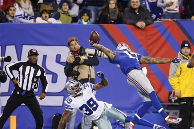 FILE - In this Nov. 23, 2014, file photo, New York Giants wide receiver Odell Beckham Jr. (13) makes a one-handed catch for a touchdown against Dallas Cowboys cornerback Brandon Carr (39) in the second quarter of an NFL football game in East Rutherford, N.J. The one-handed catch by Odell Beckham Jr. that became the most talked-about play from Sunday did more than just boost his standing with the New York Giants, it paid off a routine growing popular among many skill players of practicing the impractical, one-handed circus grab.  (AP Photo/Kathy Willens, File)