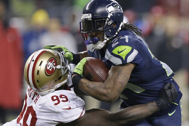 Seattle Seahawks' Marshawn Lynch tries to run past San Francisco 49ers' Aldon Smith during the second half of the NFL football NFC Championship game Sunday, Jan. 19, 2014, in Seattle. (AP Photo/Elaine Thompson)