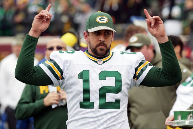 Green Bay Packers quarterback Aaron Rodgers signals touchdown as officials review one during the second half of an NFL football game against the Minnesota Vikings, Sunday, Nov. 23, 2014, in Minneapolis. (AP Photo/Jim Mone)