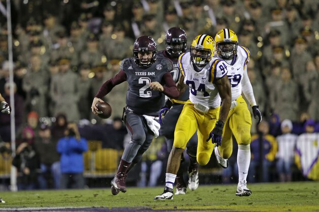 Texas A&M quarterback Johnny Manziel (2) rushes past LSU defensive end Danielle Hunter (94) in the second half of an NCAA college football game in Baton Rouge, La., Saturday, Nov. 23, 2013. LSU won 34-10. (AP Photo/Gerald Herbert)