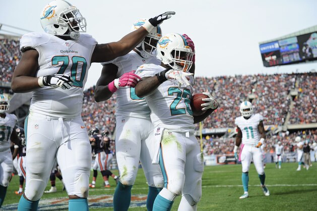 CHICAGO, IL - OCTOBER 19: Lamar Miller #26 of the Miami Dolphins celebrates his touchdown with Ja'Wuan James #70 and Dion Sims #80  during the third quarter of the game against the Chicago Bears at Soldier Field on October 19, 2014 in Chicago. The Dolphins defeated the Bears 27-14. (Photo by John Konstantaras/Getty Images)
