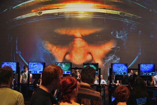 **ARCHIV**  Besucher betrachten das StarCraft am 23. Aug. 2007, auf der Games Convention, Europas Leitmesse fuer interaktive Unterhaltung, in Leipzig. Eine Gruppe von Kommunikationswissenschaftlern zeichnet in einer soeben veroeffentlichten Studie ein Bild der Computerspieler, das so gar nicht dem Klischee entspricht. Die Menschen, die sich dem Freizeitvergnuegen Computerspiel hingeben, sind demnach keine isolierten Einzelgaenger am Abgrund von Sucht und Gewalt, sondern besonders kommunikative Zeitgenossen mit einer Vorliebe fuer Geselligkeit und anspruchsvolle Unterhaltung.**FILE**Visitors watch the game StarCraft at the Blizzard Entertainment booth at the Games Convention, the fair for interactive entertainment in Leipzig, eastern Germany, Thursday, Aug. 23, 2007. More than 500 exhibitors from 31 countries present their new products until Aug. 26, 2007.  (AP Photo/Eckehard Schulz)