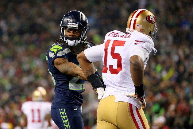 SEATTLE, WA - JANUARY 19:  Cornerback Richard Sherman #25 of the Seattle Seahawks talks with the referee after being called for an unsportsmanlike penalty for taunting wide receiver Michael Crabtree #15 of the San Francisco 49ers late in the fourth quarter during the 2014 NFC Championship at CenturyLink Field on January 19, 2014 in Seattle, Washington.  (Photo by Ronald Martinez/Getty Images)
