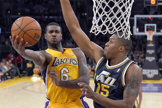 Los Angeles Lakers forward Earl Clark, left, puts up a shot as Utah Jazz forward Derrick Favors defends during the first half of an NBA basketball game, Friday, Jan. 25, 2013, in Los Angeles. (AP Photo/Mark J. Terrill)