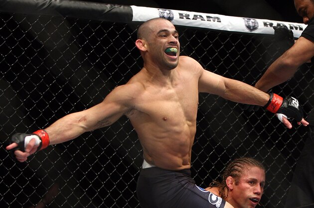 Renan Barao, left, of Brazil celebrates after the official called the fight against Urijah Faber of Sacramento, CA during the first  round of the Ultimate Fighting Bantamweight Championship Mixed Martial Arts bout in Newark, N.J. on Saturday, Feb. 1, 2014. Barao won after referee Herb Dean called the fight in the first round. (AP Photo/Tim Larsen)
