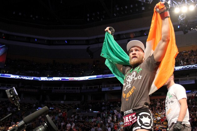 Conor McGregor, of Ireland, leaves the ring draped in an Irish flag after beating Max Holloway in their UFC on Fox Sports 1 mixed martial arts bout in Boston, Saturday, August 17,2013. McGregor won via unanimous decision. (AP Photo/Gregory Payan)