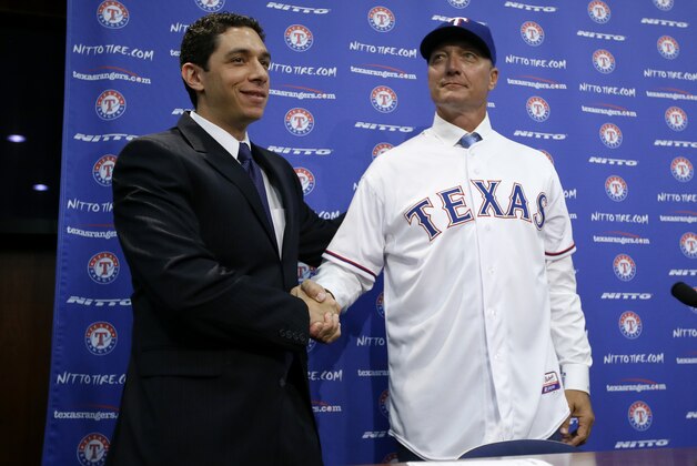 Texas Rangers President of Baseball Operations and General Manager Jon Daniels, left, shakes hands with newly hired manager Jeff Banister after presenting him with his team jersey at a news conference, Friday, Oct. 17, 2014, in Arlington, Texas. (AP Photo/Tony Gutierrez)
