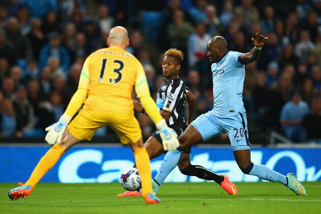 MANCHESTER, ENGLAND - OCTOBER 29: Rolando Aarons of Newcastle United scores the opening goal under pressure from Eliaquim Mangala of Manchester City  during the Capital One Cup Fourth Round match between Manchester City and Newcastle United at Etihad Stadium on October 29, 2014 in Manchester, England.  (Photo by Richard Heathcote/Getty Images)