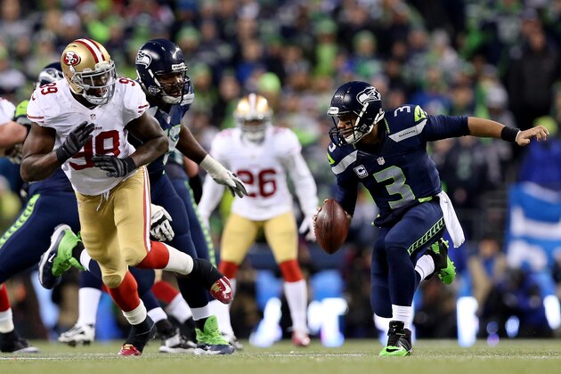 SEATTLE, WA - JANUARY 19:  Quarterback Russell Wilson #3 of the Seattle Seahawks is pressured by outside linebacker Aldon Smith #99 of the San Francisco 49ers during the 2014 NFC Championship at CenturyLink Field on January 19, 2014 in Seattle, Washington.  (Photo by Christian Petersen/Getty Images)