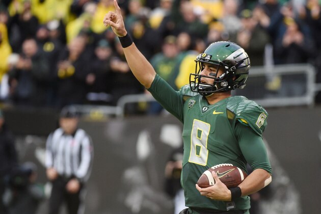 Oregon quarterback Marcus Mariota (8) celebrates after scoring a touchdown during the first quarter of an NCAA college football game against the Colorado on Saturday, Nov. 22, 2014, in Eugene, Ore. (AP Photo/Steve Dykes)
