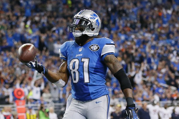 Detroit Lions wide receiver Calvin Johnson tosses the ball after his 25-yard reception for a touchdown during the first half of an NFL football game against the Chicago Bears in Detroit, Thursday, Nov. 27, 2014. (AP Photo/Rick Osentoski)