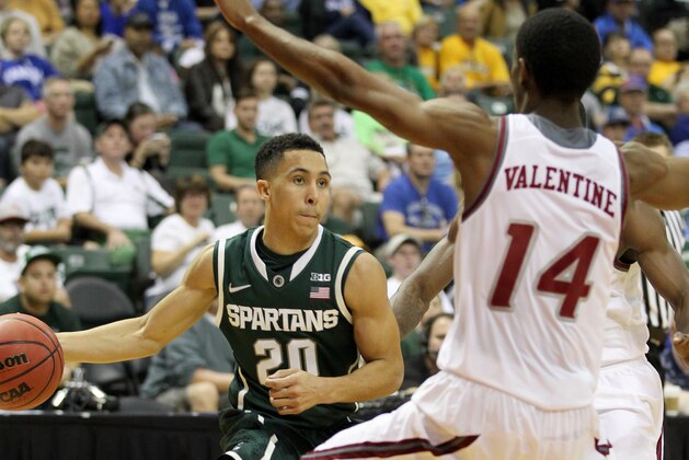 Michigan State guard Travis Trice (20) drives past Rider forward Shawn Valentine (14) during the first half of an NCAA college basketball game in Lake Buena Vista, Fla., Thursday, Nov. 27, 2014. (AP Photo/Reinhold Matay)