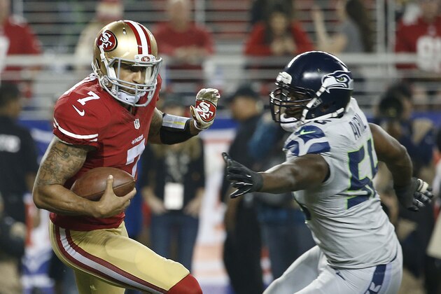 San Francisco 49ers quarterback Colin Kaepernick (7) scrambles from Seattle Seahawks defensive end Cliff Avril (56) during the first half of an NFL football game in Santa Clara, Calif., Thursday, Nov. 27, 2014. (AP Photo/Tony Avelar)