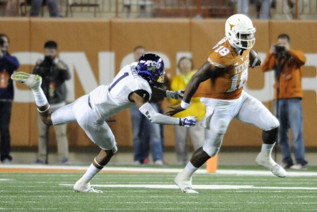 Nov 27, 2014; Austin, TX, USA; Texas Longhorns quarterback Tyrone Swoopes (18) runs past TCU Horned Frogs safety Chris Hackett (1) during the game at Darrell K Royal-Texas Memorial Stadium. Mandatory Credit: Brendan Maloney-USA TODAY Sports