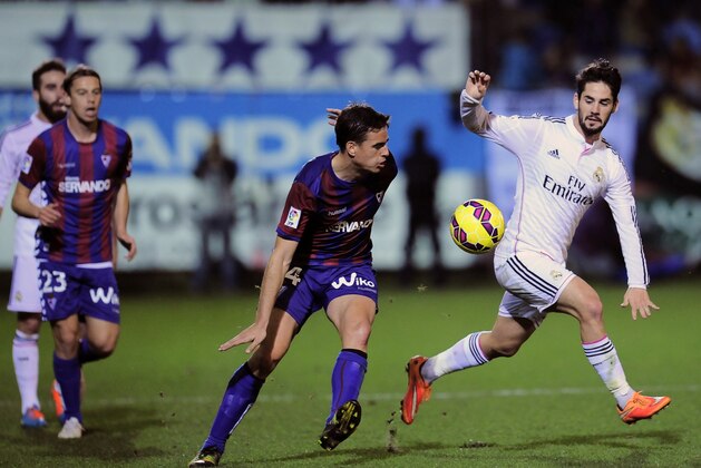 Real Madrid's Isco, right, duels for the ball in front SD Eibar's Dani Garcia, during their La Liga soccer match, at Ipurua stadium in Eibar, northern Spain, Saturday Nov. 22, 2014. Real Madrid won 4-0. (AP Photo/Alvaro Barrientos)