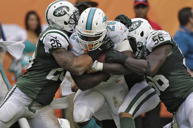 New York Jets strong safety Dawan Landry (26) and inside linebacker DeMario Davis (56) stop Miami Dolphins running back Lamar Miller (26) during the third quarter of an NFL football game Sunday, Dec. 29, 2013, in Miami Gardens, Fla. (AP Photo/Lynne Sladky)