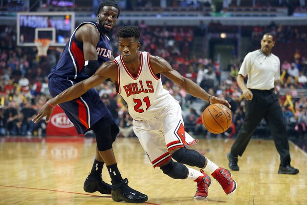Chicago Bulls guard Jimmy Butler (21) gets past Atlanta Hawks forward DeMarre Carroll during the first half of a preseason NBA basketball game in Chicago, on Thursday, Oct. 16, 2014. (AP Photo/Jeff Haynes)
