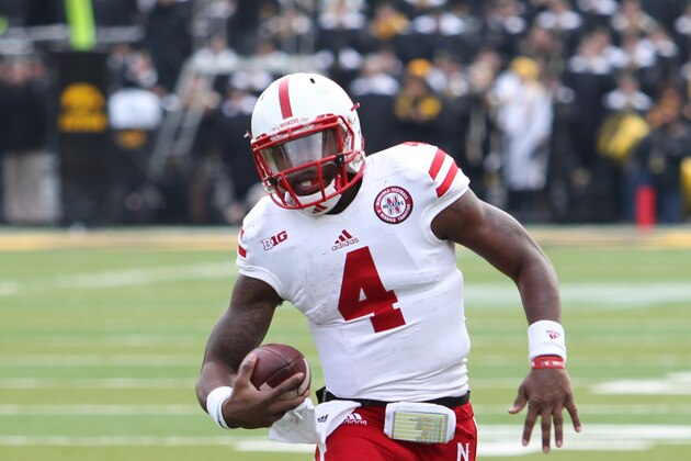 Nov 28, 2014; Iowa City, IA, USA; Nebraska Cornhuskers quarterback Tommy Armstrong Jr. (4) runs for a first down against the Iowa Hawkeyes at Kinnick Stadium. Nebraska beat Iowa 37-34.  Mandatory Credit: Reese Strickland-USA TODAY Sports