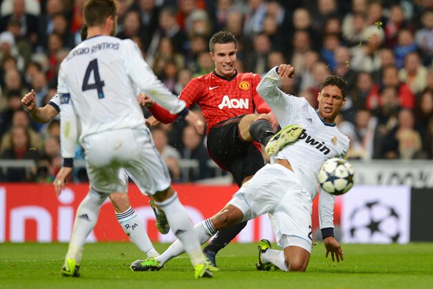 MADRID, SPAIN - FEBRUARY 13:  Robin van Persie of Manchester United and Raphael Varane of Real Madrid battle for the ball during the UEFA Champions League Round of 16 first leg match between Real Madrid and Manchester United at Estadio Santiago Bernabeu on February 13, 2013 in Madrid, Spain.  (Photo by Mike Hewitt/Getty Images)